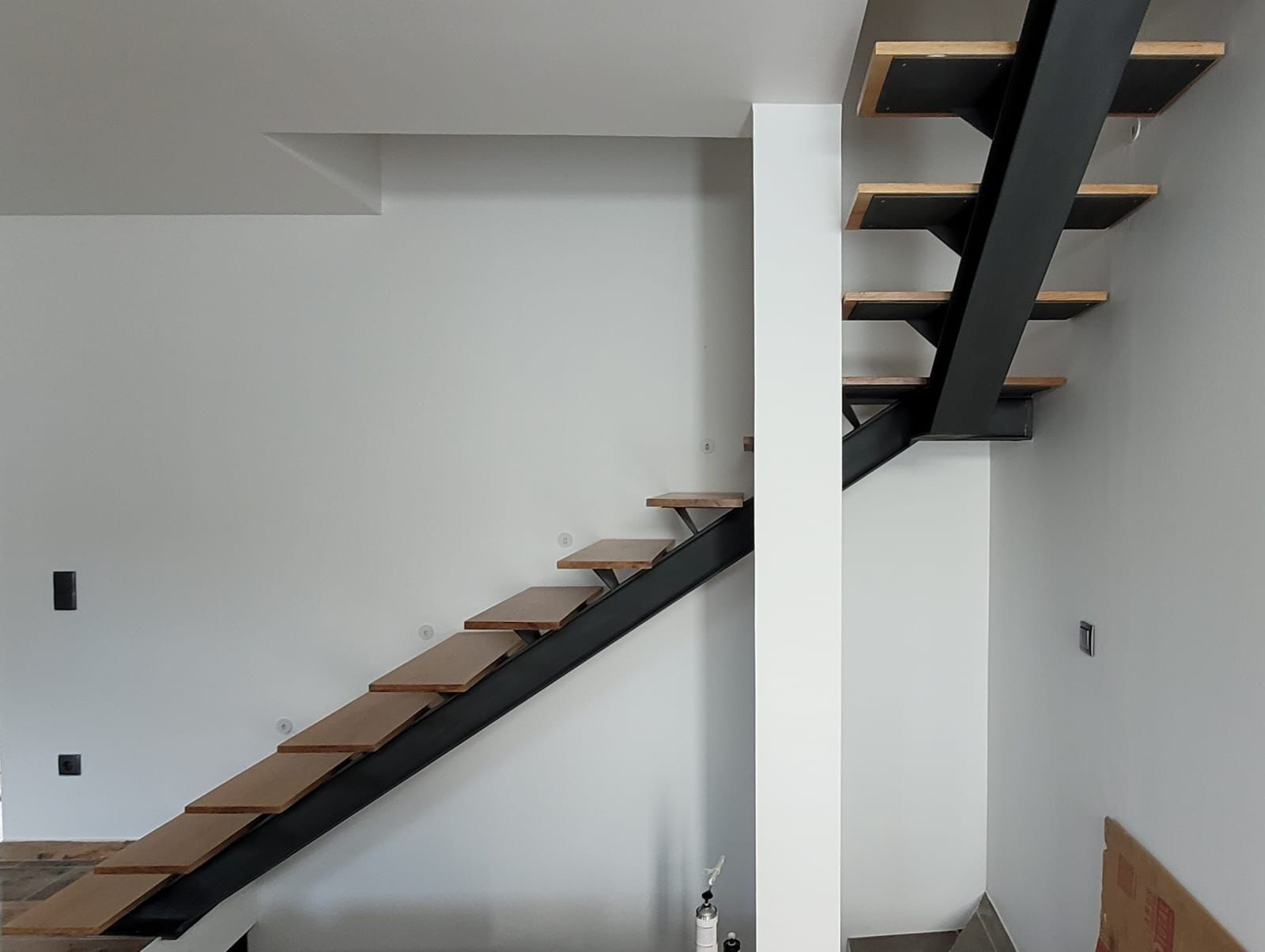 Escada interior moderna com estrutura metálica e degraus em madeira