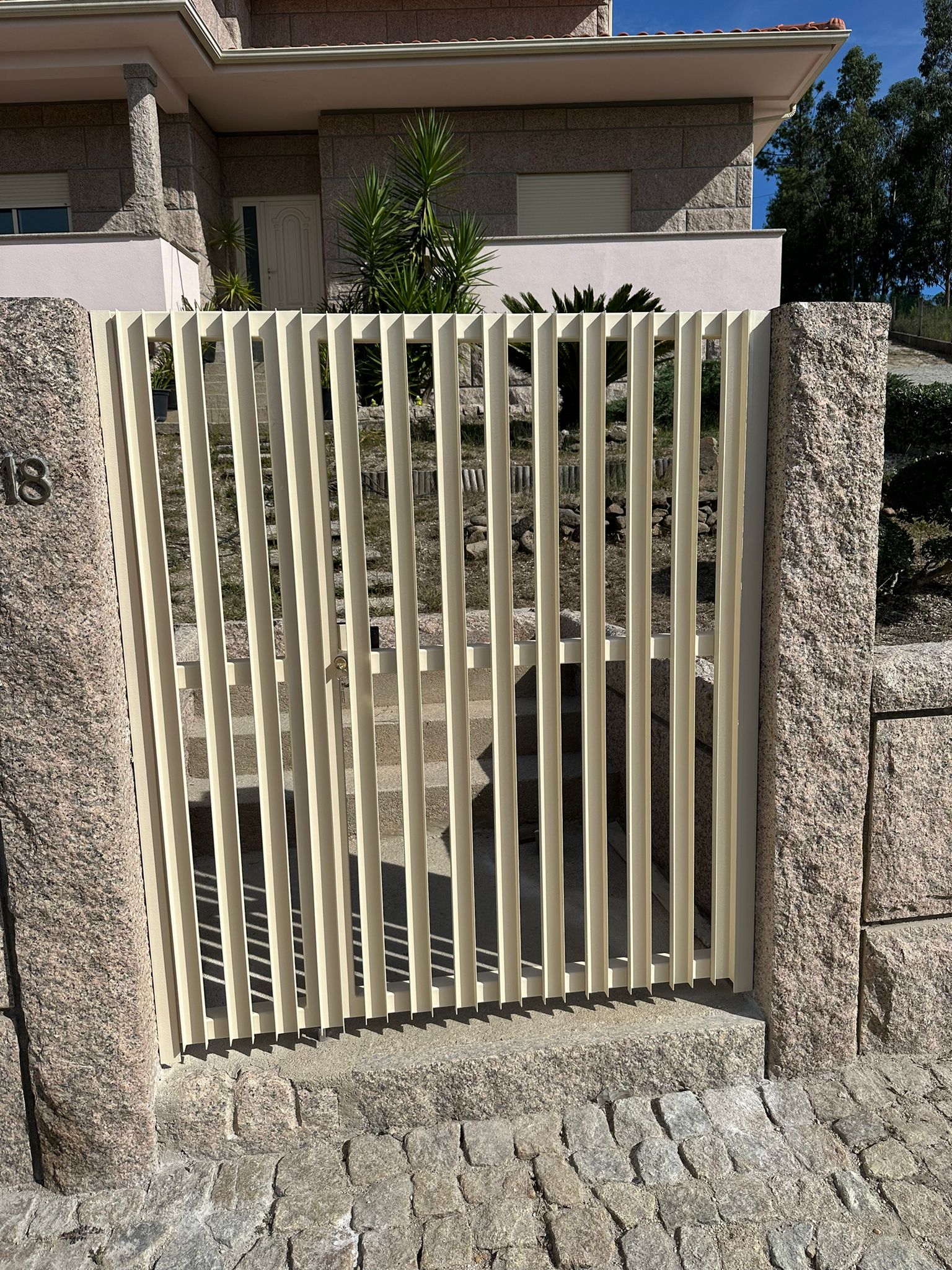 Portão pedonal bege com lâminas verticais