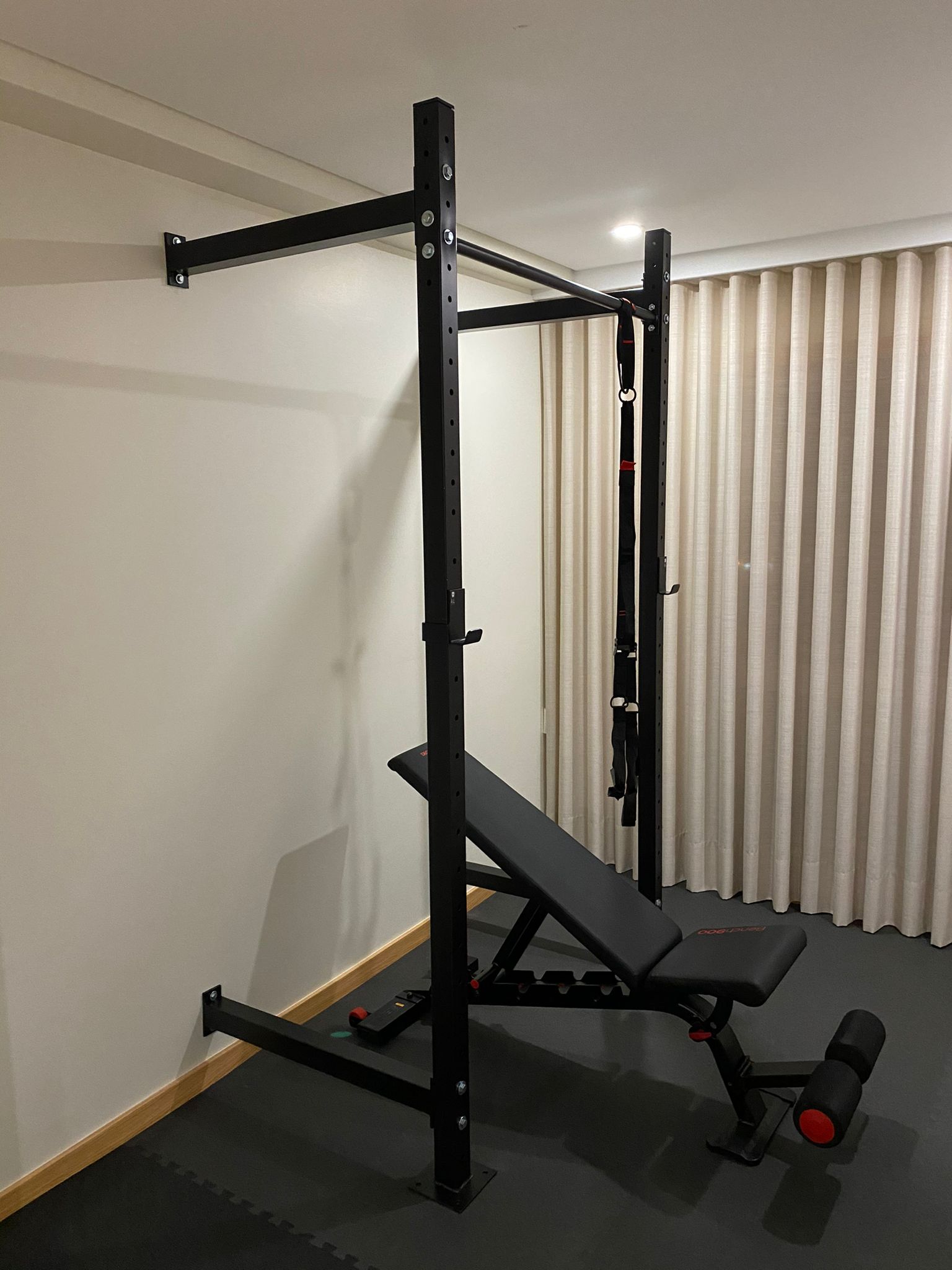 Squat rack com barra e banco ajustável em home gym