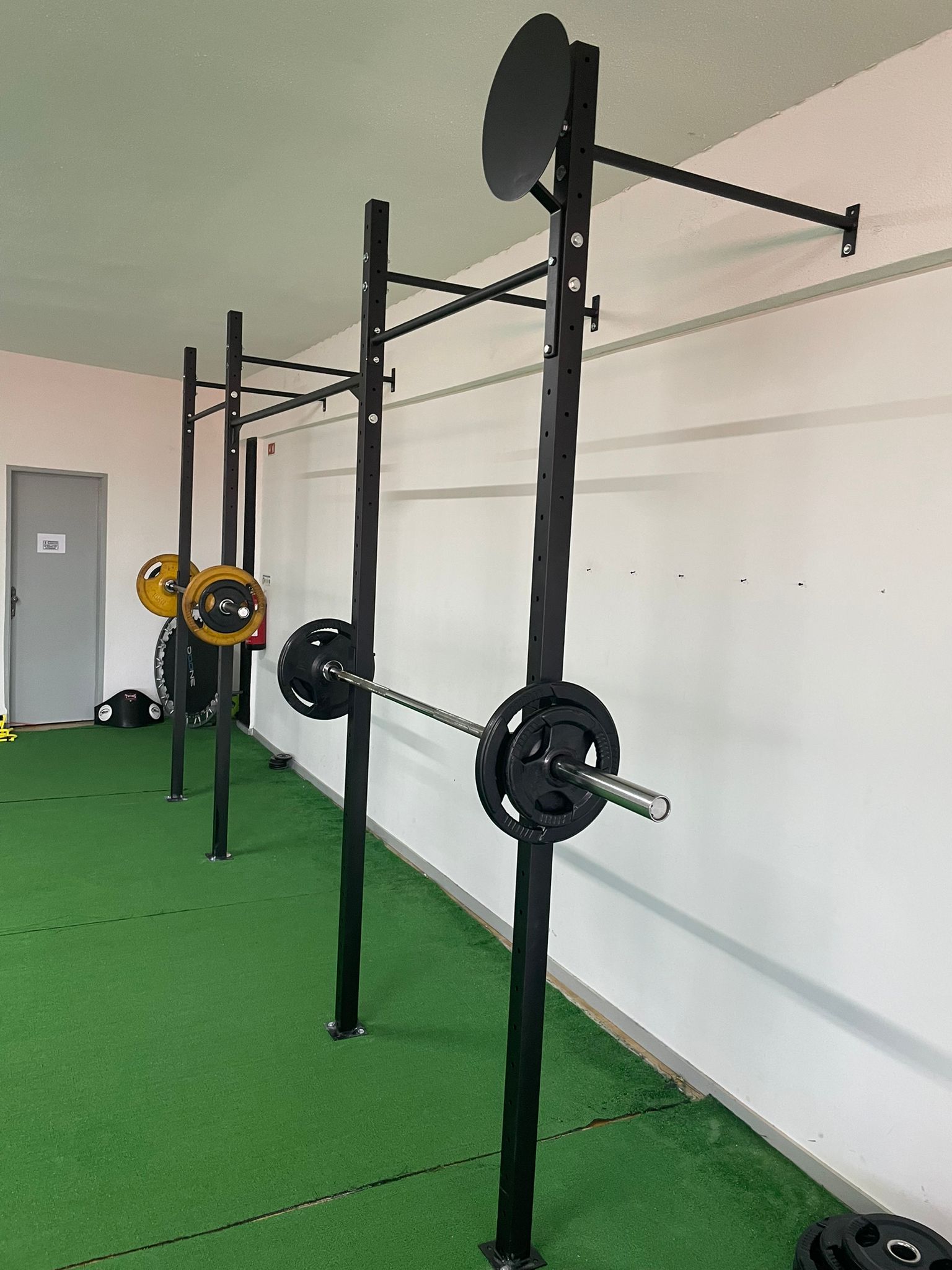 Rig de CrossFit montado na parede com estações múltiplas