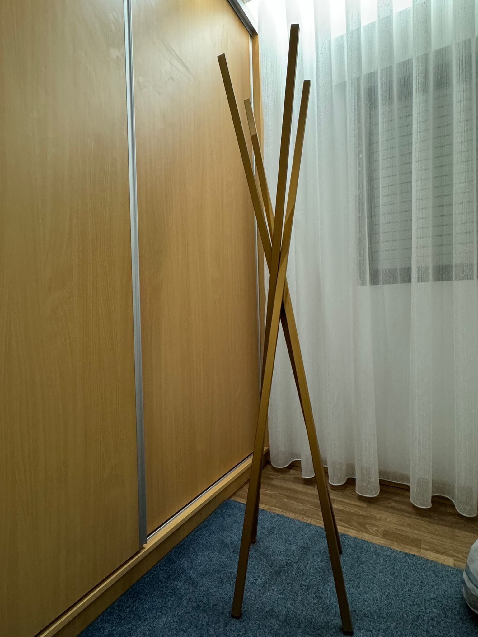 Cabide de pé metálico dourado com design minimalista